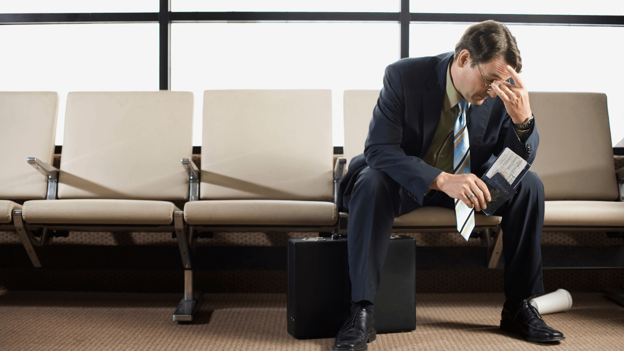 sulking business man at the airport | Scott Legal, P.C. sulking business man at the airport