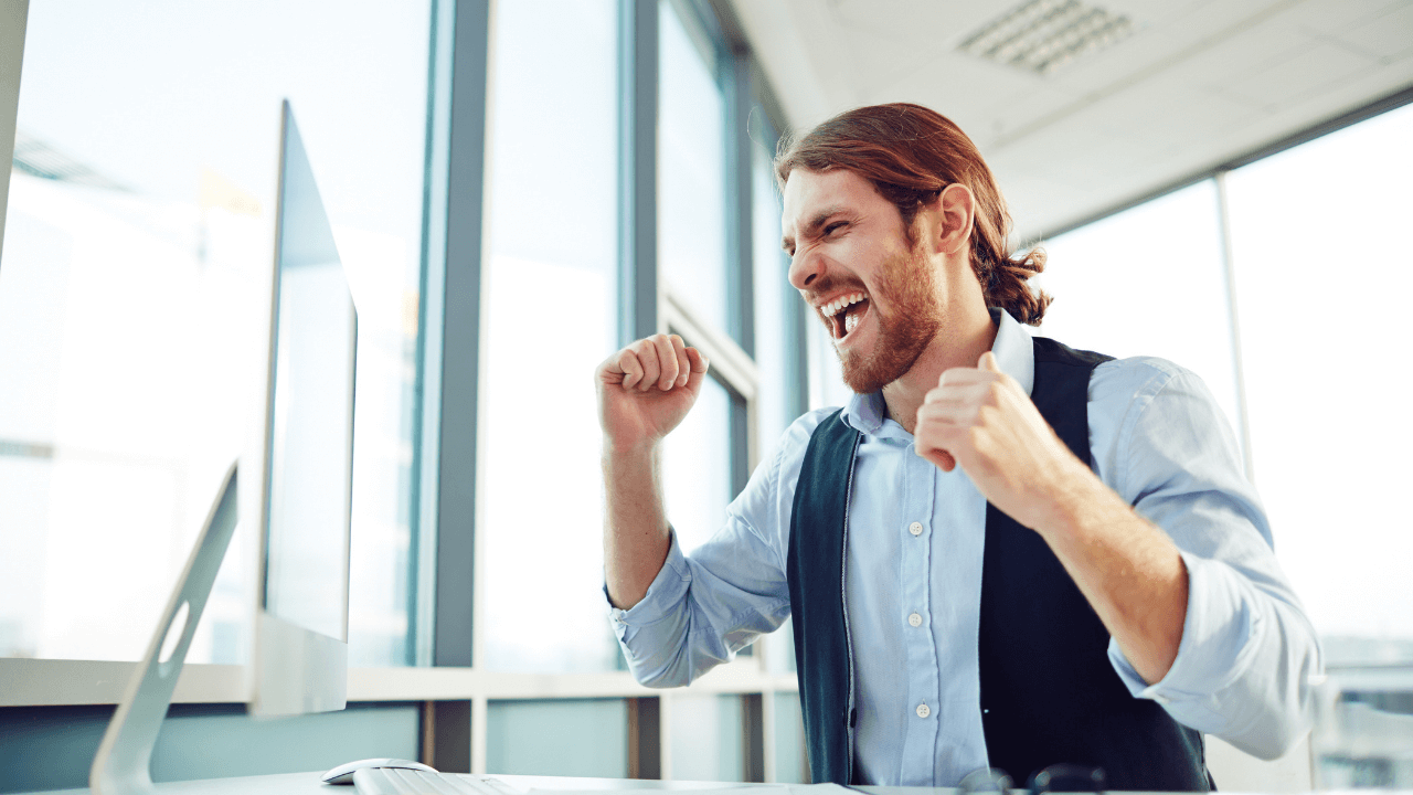 man sitting at his desk celebrating an approval | Scott Legal, P.C. man sitting at his desk celebrating an approval