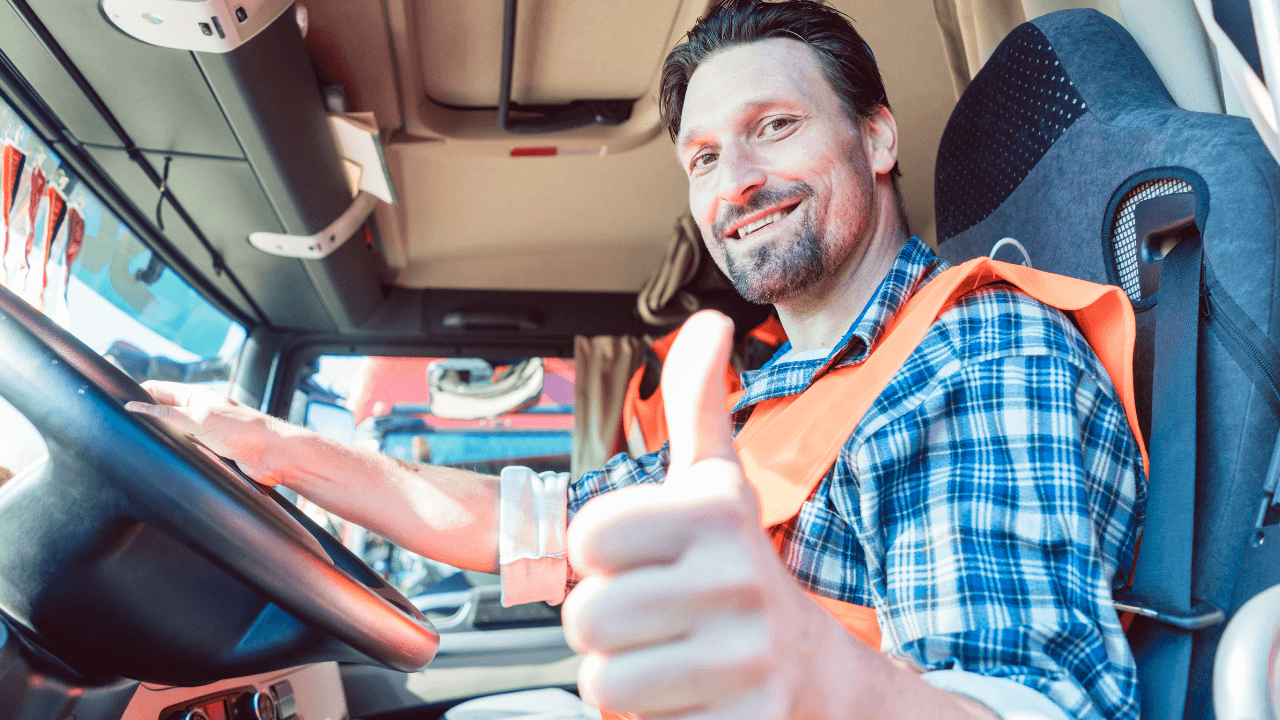A truck driver sitting in his truck, smiling at the camera while giving a thumbs up | Scott Legal, P.C. A truck driver sitting in his truck, smiling at the camera while giving a thumbs up