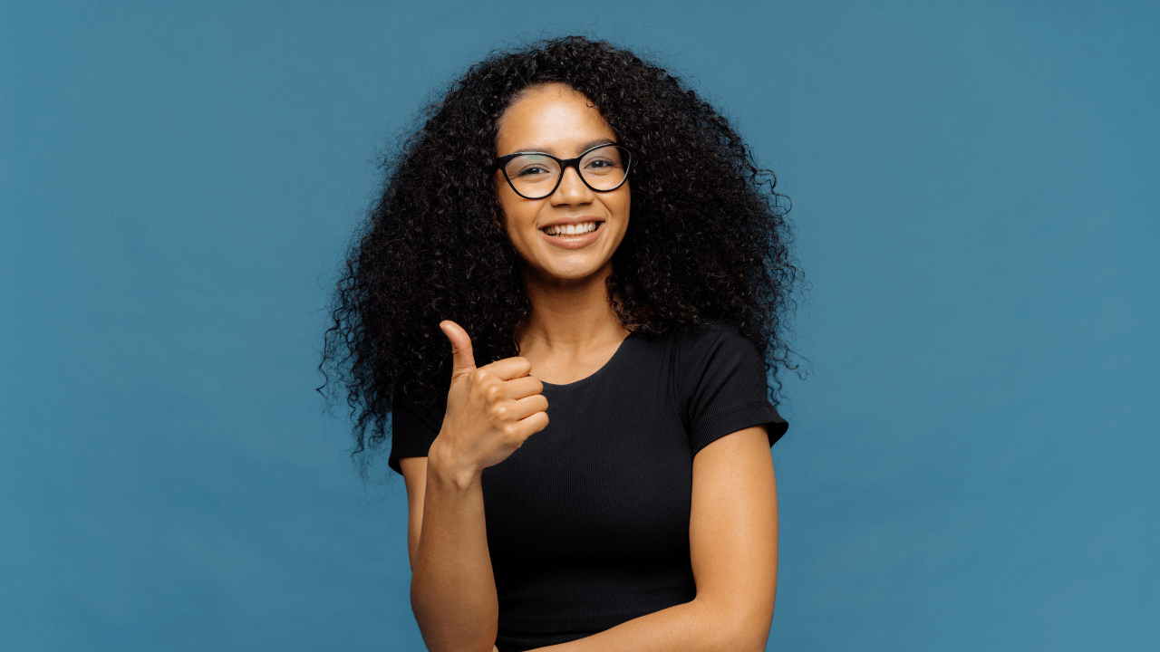 A woman smiling doing thumbs up for recent approval | Scott Legal, P.C. A woman smiling doing thumbs up for recent approval