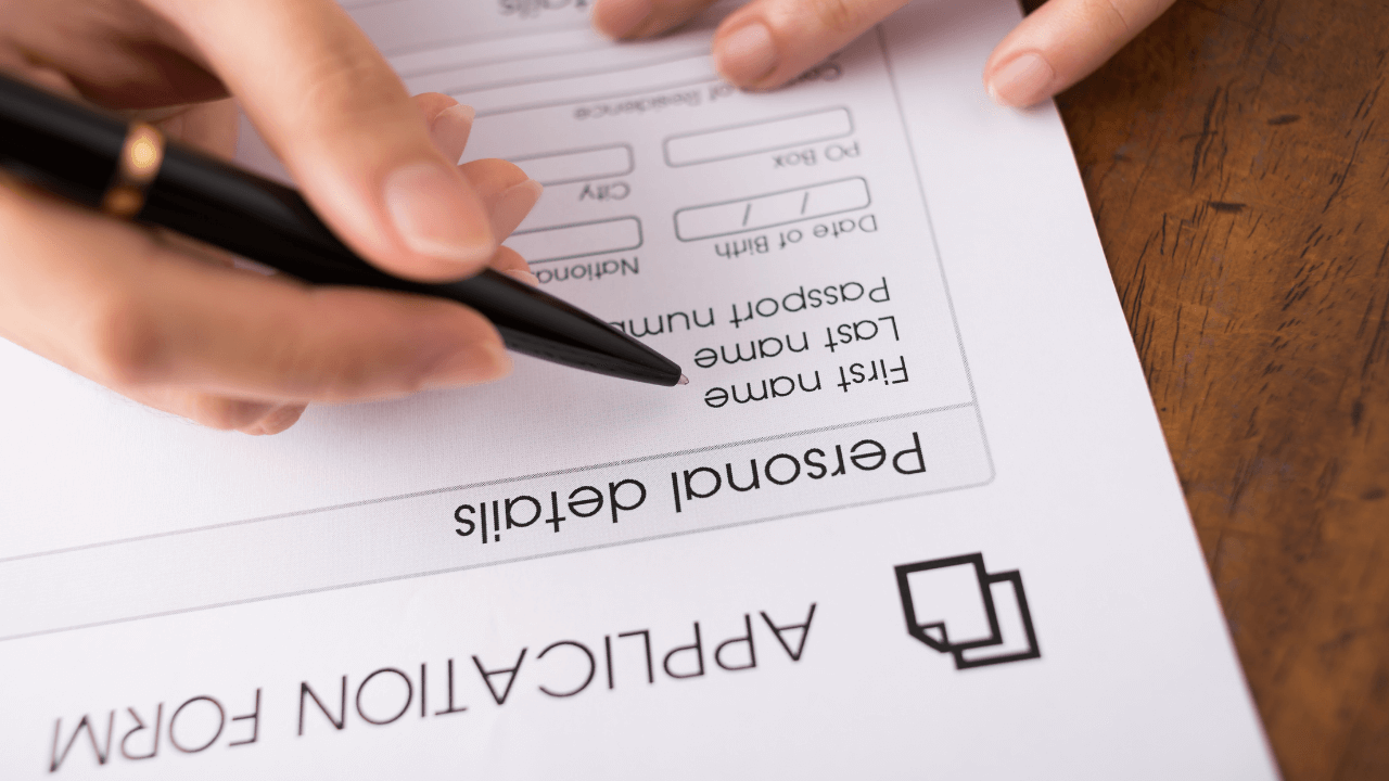 A man filling out an application package with a pen | Scott Legal, P.C. A man filling out an application package with a pen