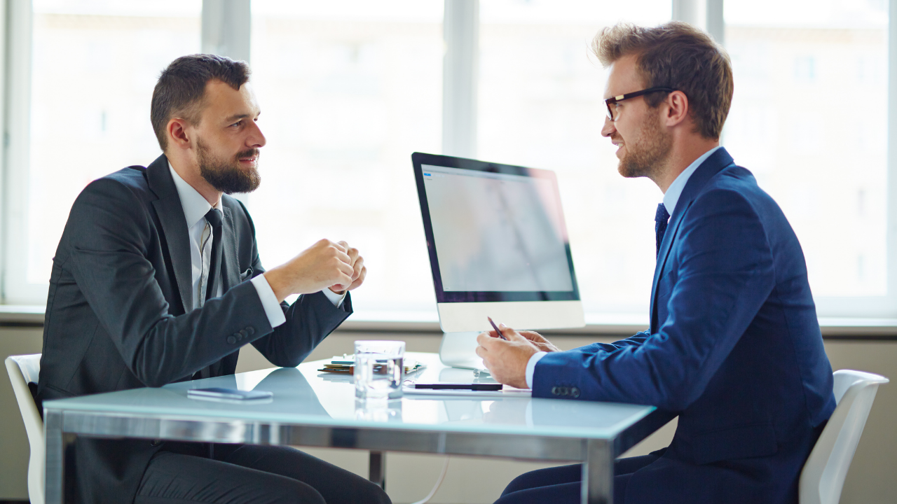 Two business men speaking in their office | Scott Legal, P.C. Two business men speaking in their office