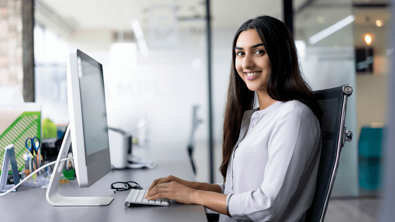 a woman seated at her desk while working on her desktop computer | Scott Legal, P.C. a woman seated at her desk while working on her desktop computer