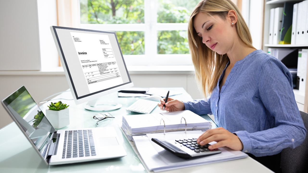 A woman working on invoicing at her office desk | Scott Legal, P.C. A woman working on invoicing at her office desk