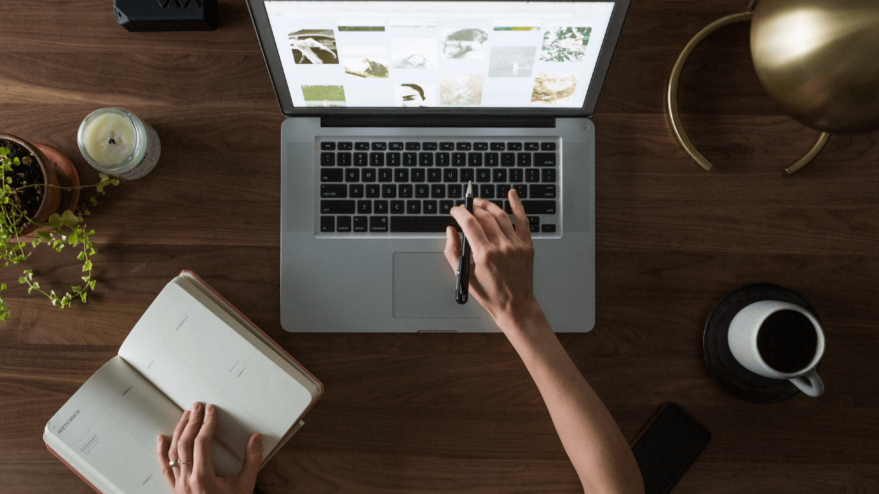 A man or woman doing research on their laptop, with a pen and paper handy for notes | Scott Legal, P.C. A man or woman doing research on their laptop, with a pen and paper handy for notes