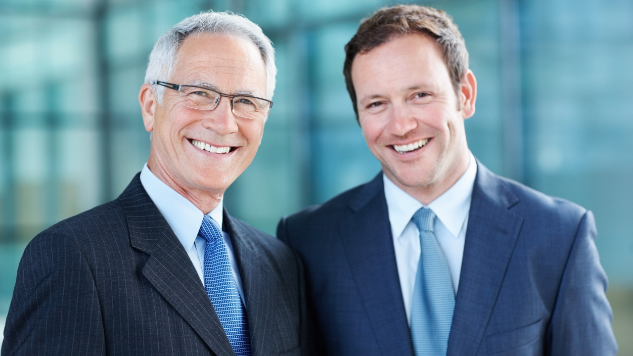 Two business partners dressed in suits smiling | Scott Legal, P.C. Two business partners dressed in suits smiling