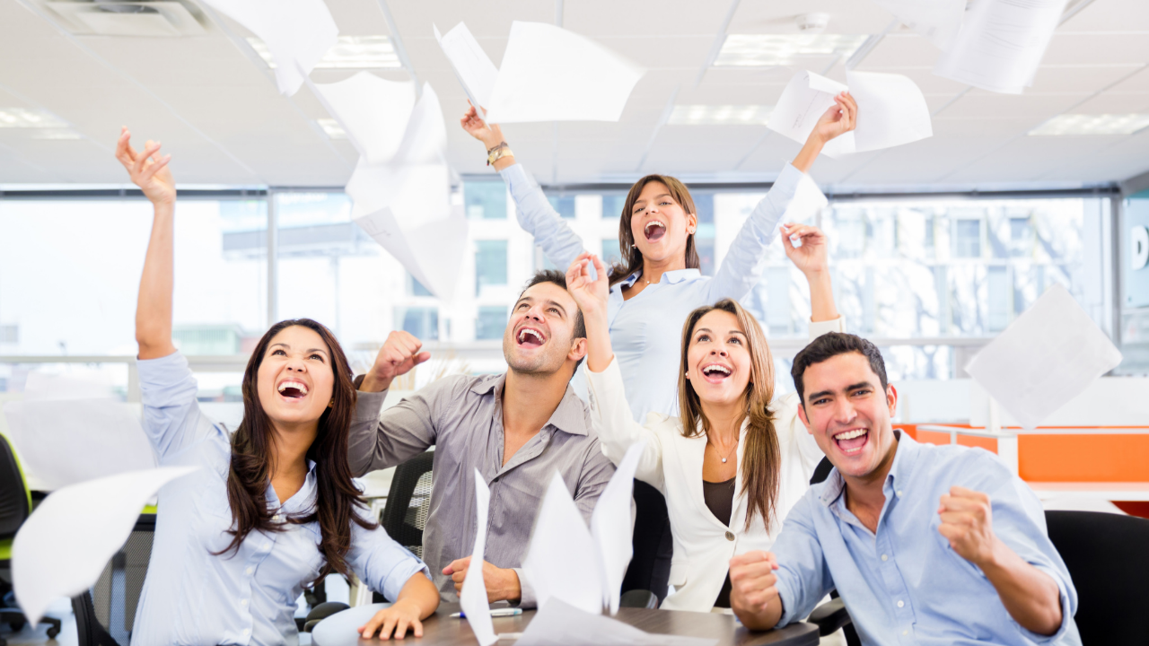 An office team celebrating an approval by throwing papers and their arms in the air | Scott Legal, P.C. An office team celebrating an approval by throwing papers and their arms in the air