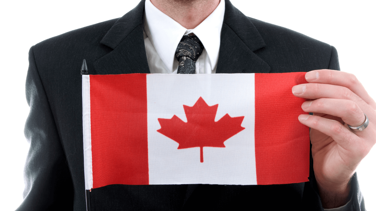 A business owner holding a Canadian flag | Scott Legal, P.C. A business owner holding a Canadian flag
