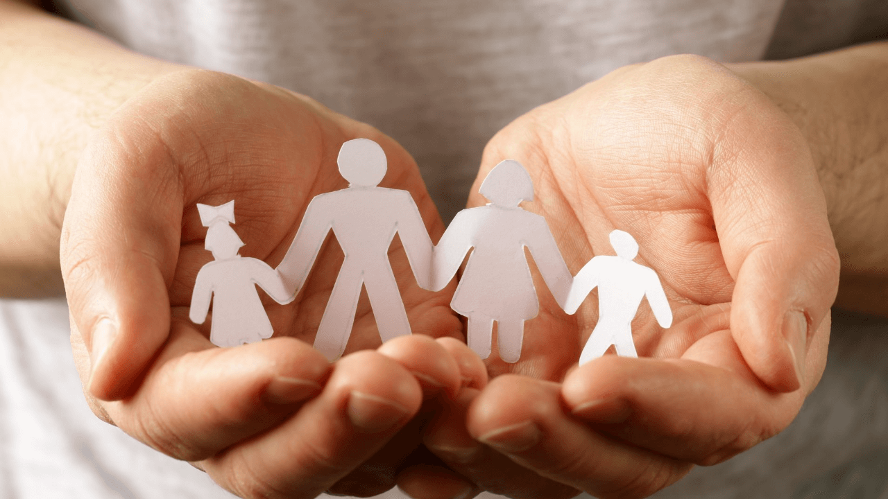 An individual holding a paper cut out of a family | Scott Legal, P.C. An individual holding a paper cut out of a family