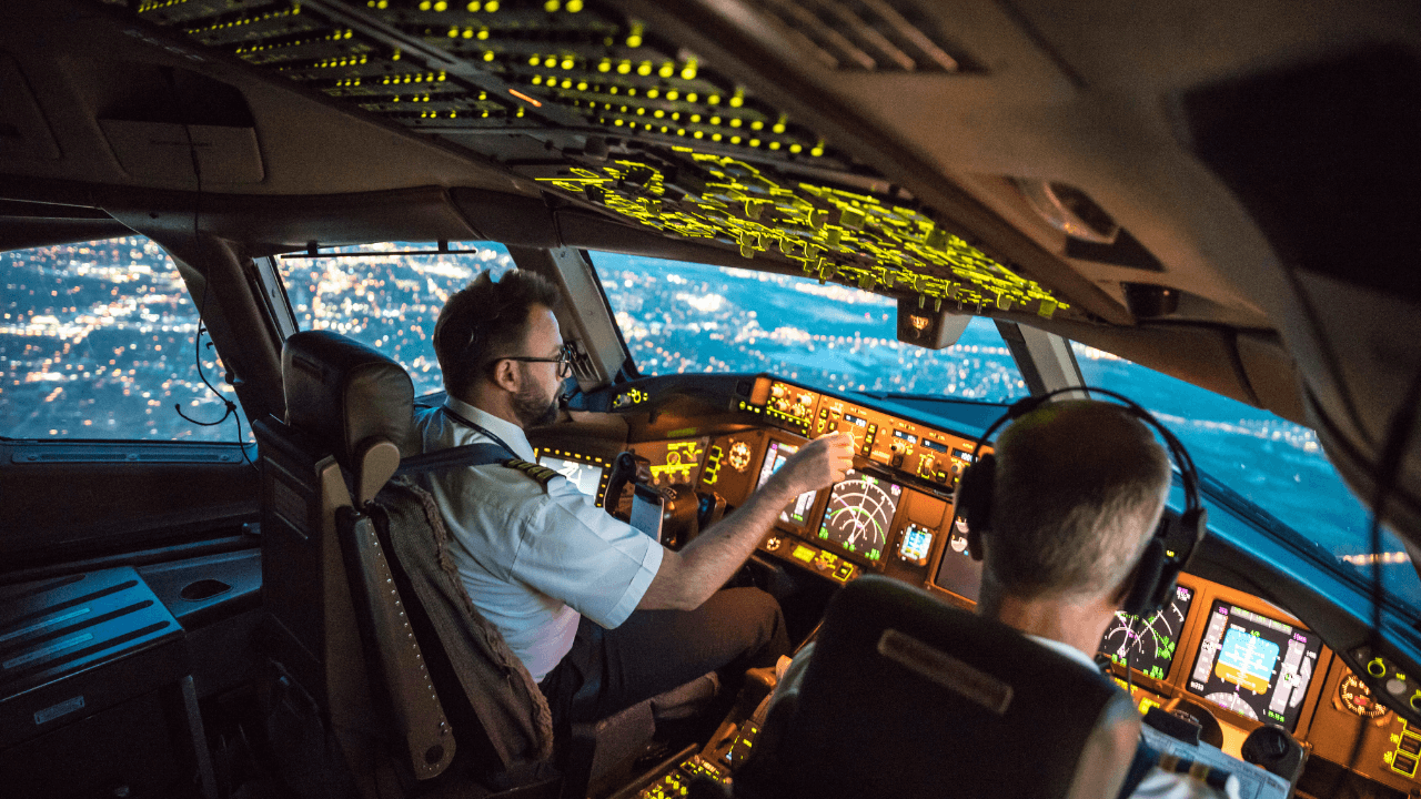 Two pilots sitting in the cockpit of an airplane that is in the air | Scott Legal, P.C. Two pilots sitting in the cockpit of an airplane that is in the air