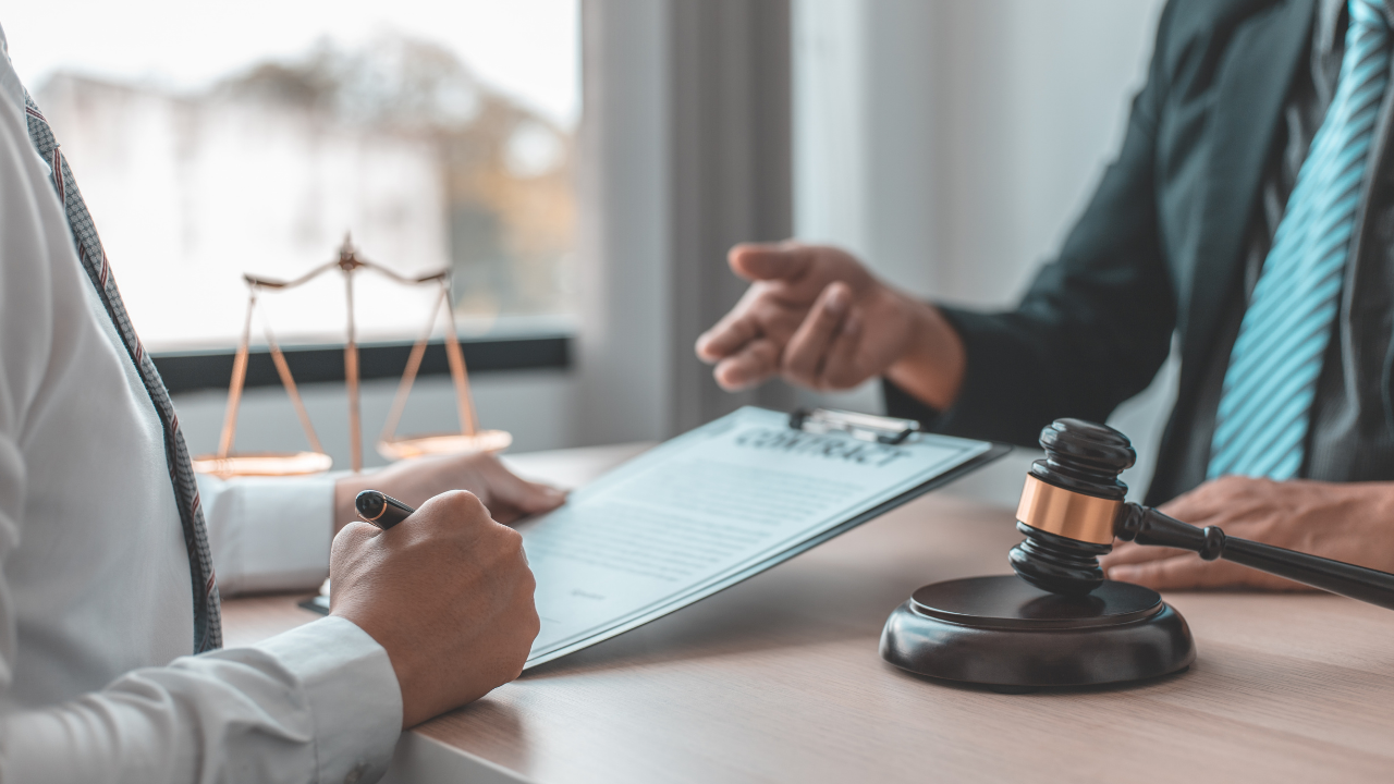 A woman consulting her lawyer in his office | Scott Legal, P.C. A woman consulting her lawyer in his office