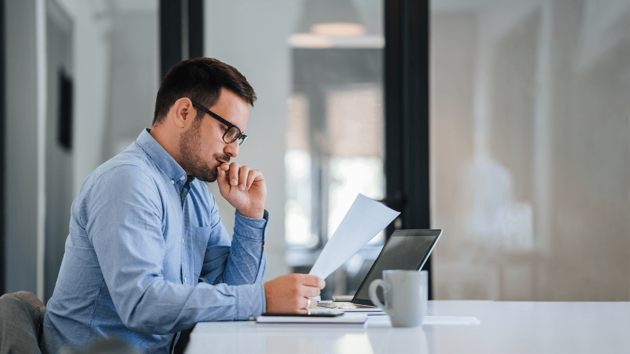A business immigration analyst reviewing documents while sitting in the office | Scott Legal, P.C. A business immigration analyst reviewing documents while sitting in the office