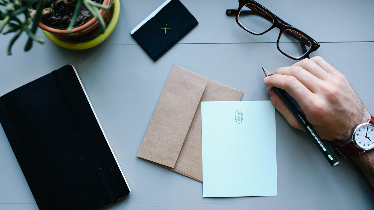 A business man writing a letter on his desk | Scott Legal, P.C. A business man writing a letter on his desk