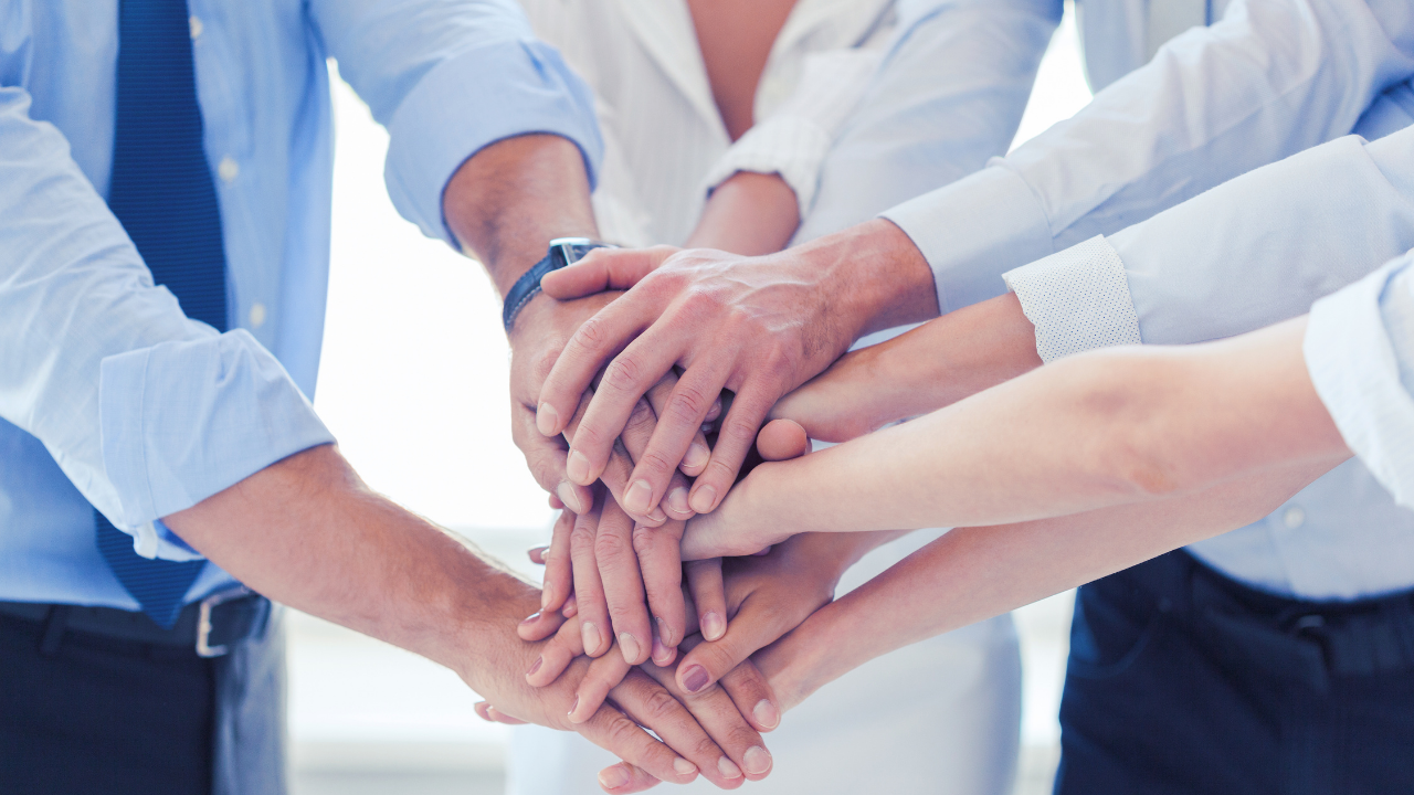 An office team stacking their hands in cooperation and teamwork | Scott Legal, P.C. An office team stacking their hands in cooperation and teamwork