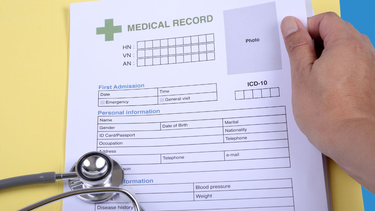 A doctor filling out a medical form | Scott Legal, P.C. A doctor filling out a medical form