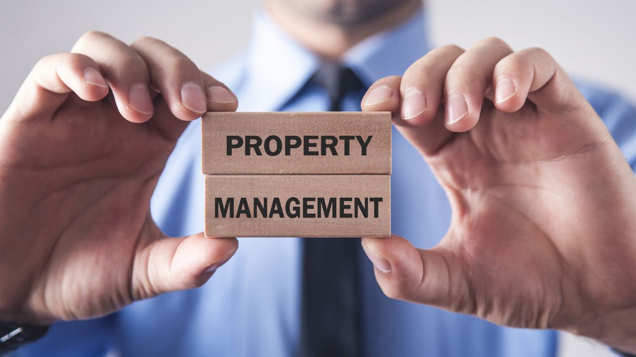 A man in a suit holding blovks that say "property management" | Scott Legal, P.C. A man in a suit holding blovks that say "property management"