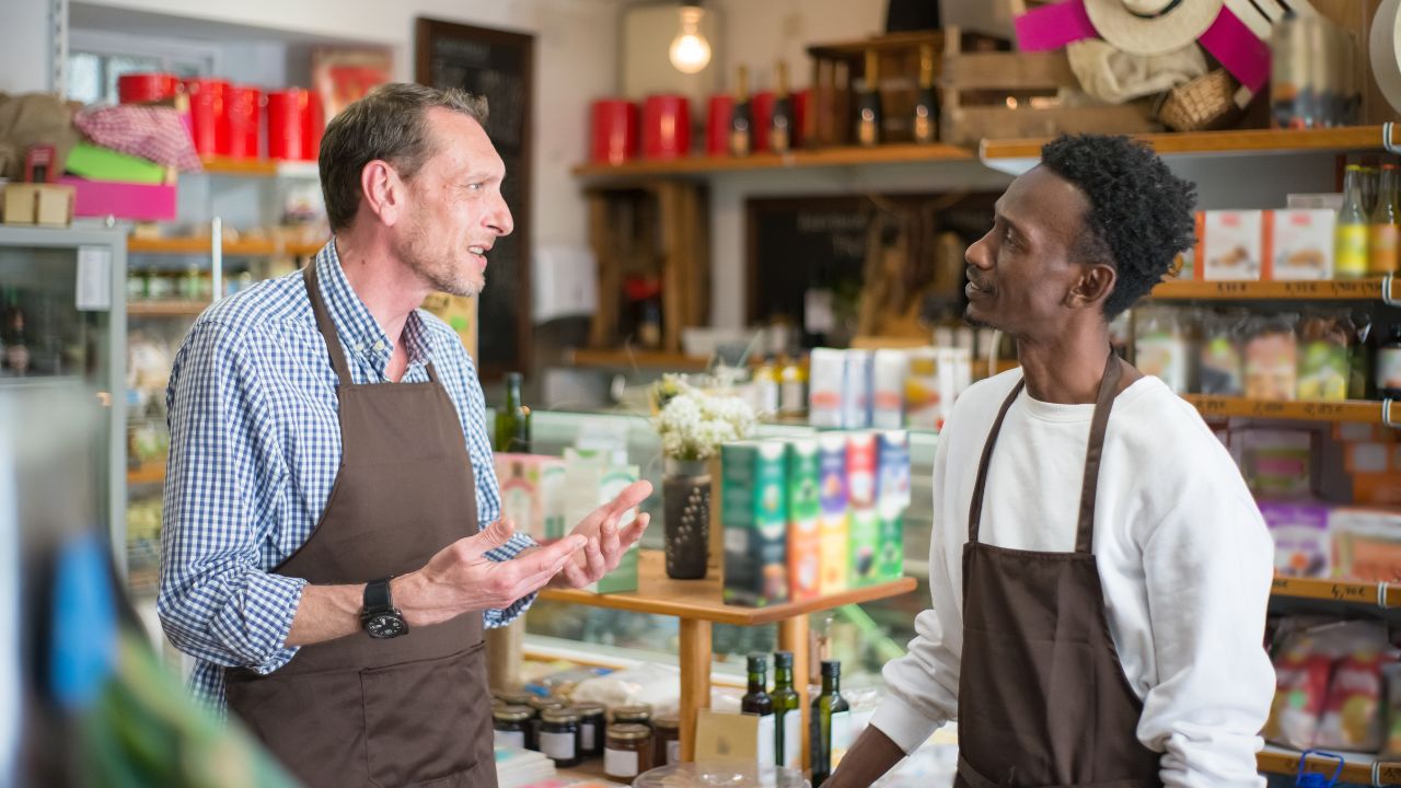 Two convenience store workers speaking to each other | Scott Legal, P.C. Two convenience store workers speaking to each other