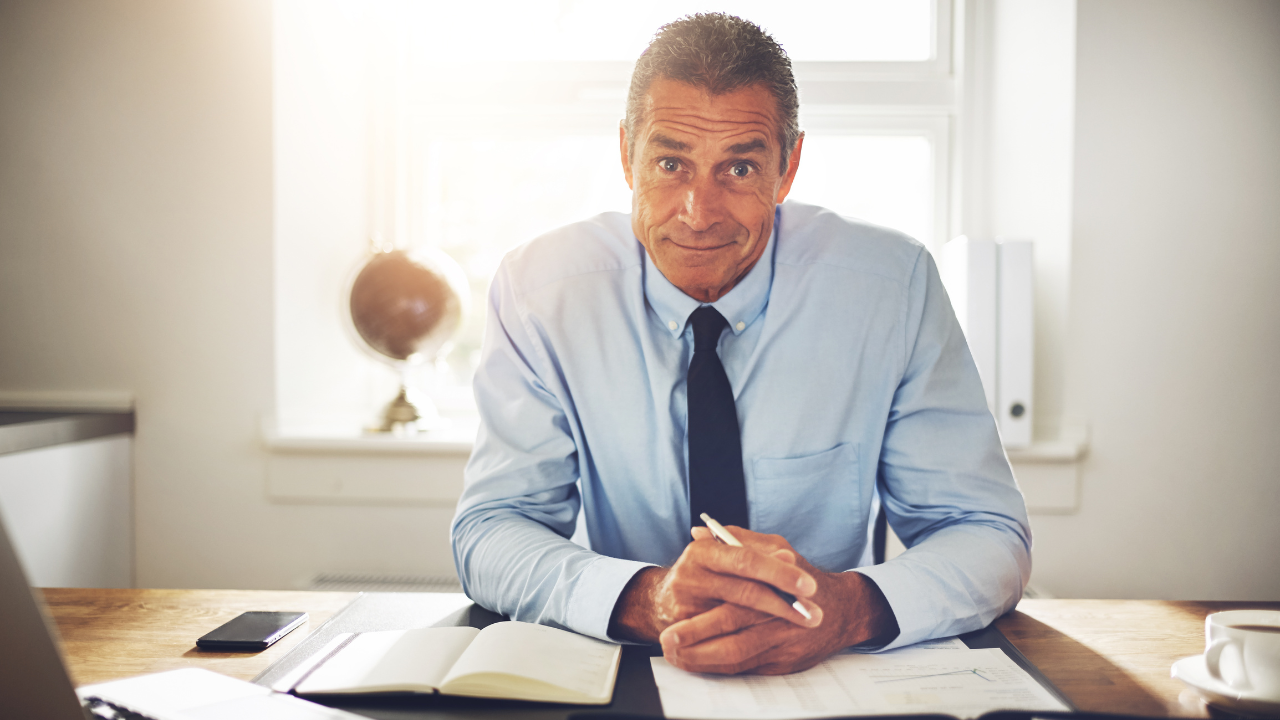 A happy executive sitting at his desk | Scott Legal, P.C. A happy executive sitting at his desk