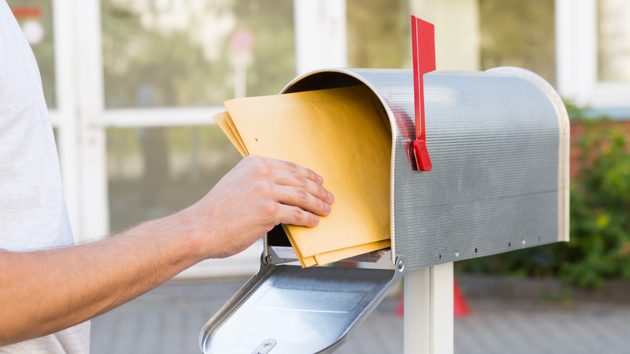 A man claiming his mail from his mailbox | Scott Legal, P.C. A man claiming his mail from his mailbox