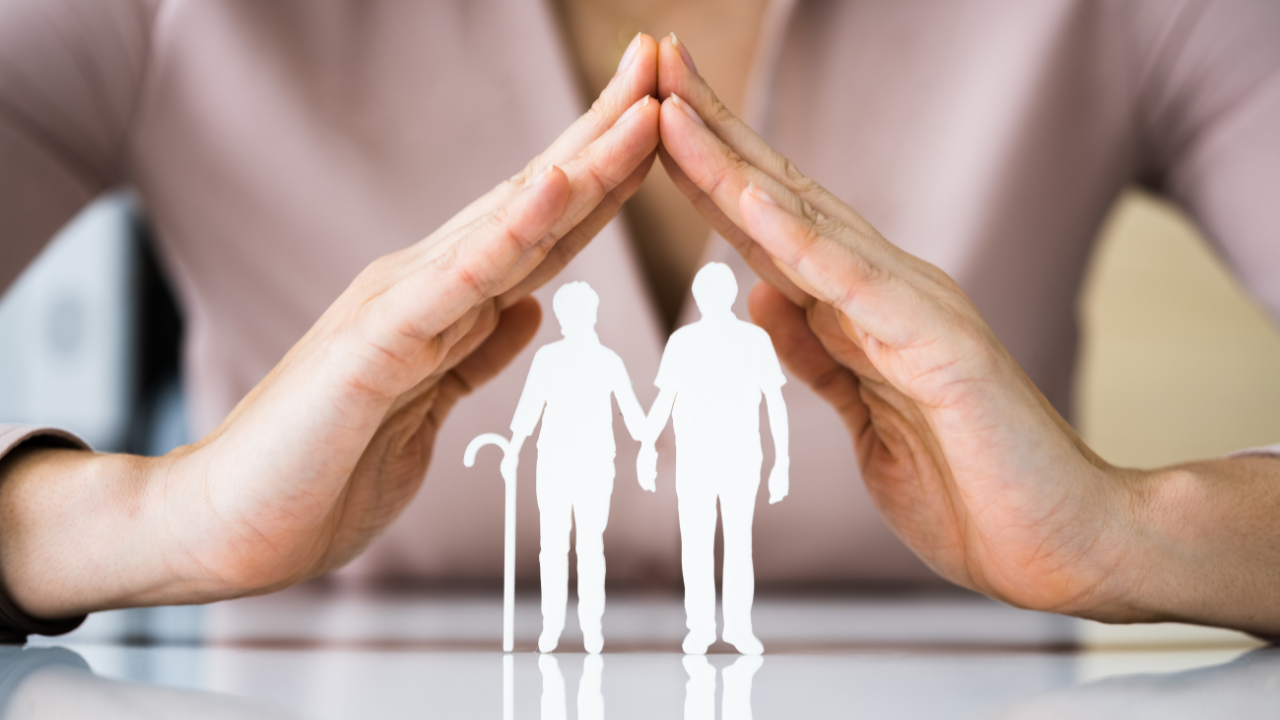 a hand protecting a paper cut out of a man and a woman | Scott Legal, P.C. a hand protecting a paper cut out of a man and a woman