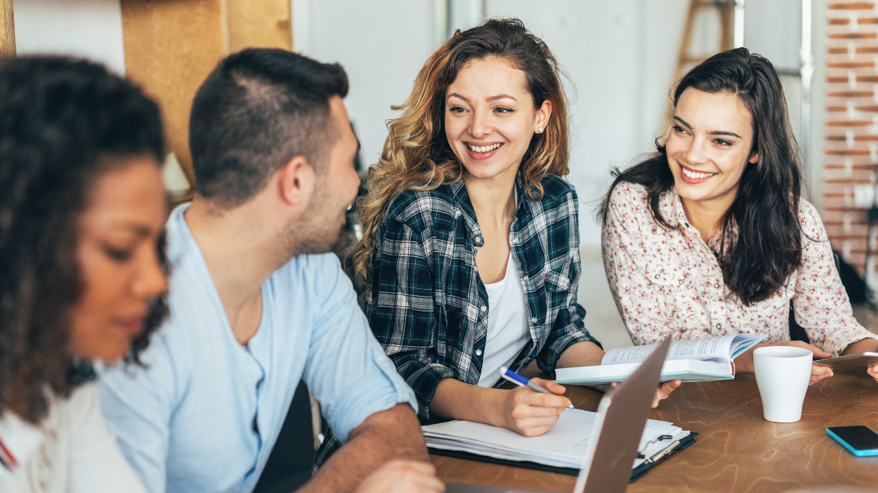 A group of university students sitting around a table in class | Scott Legal, P.C. A group of university students sitting around a table in class