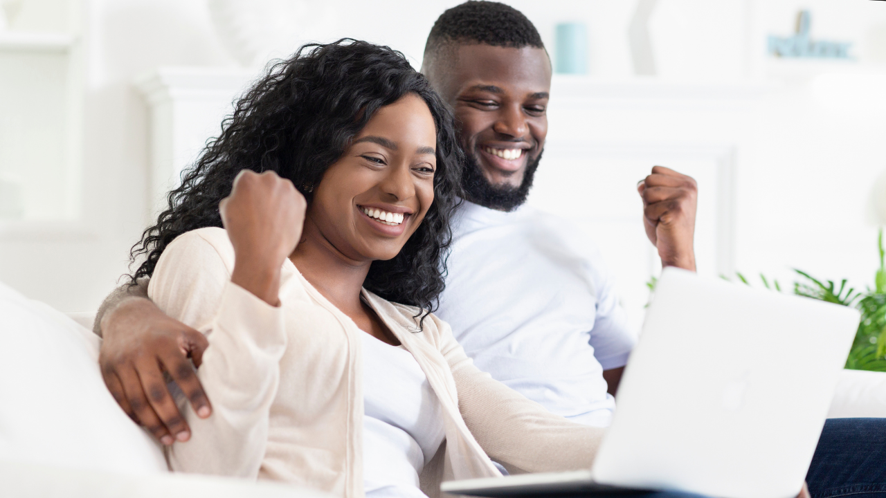 A man and woman happy to see some news on their laptop | Scott Legal, P.C. A man and woman happy to see some news on their laptop