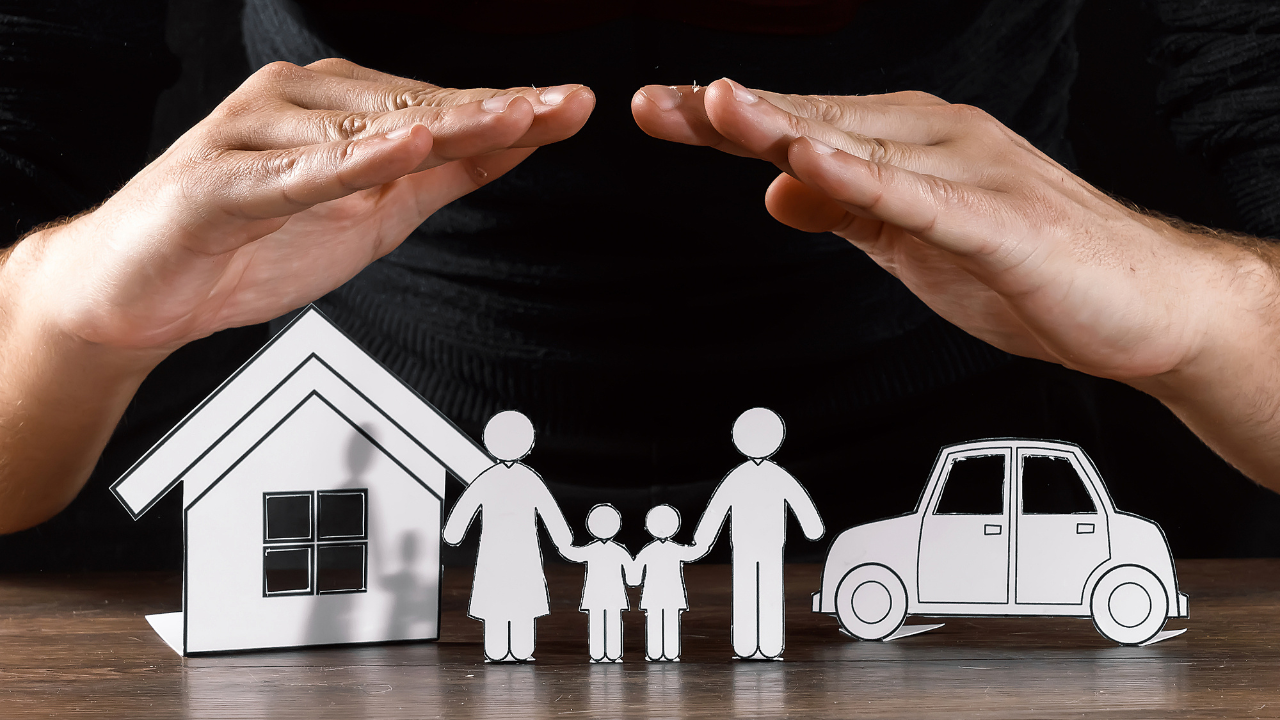 A hand protecting a cardboard cut out of a family | Scott Legal, P.C. A hand protecting a cardboard cut out of a family