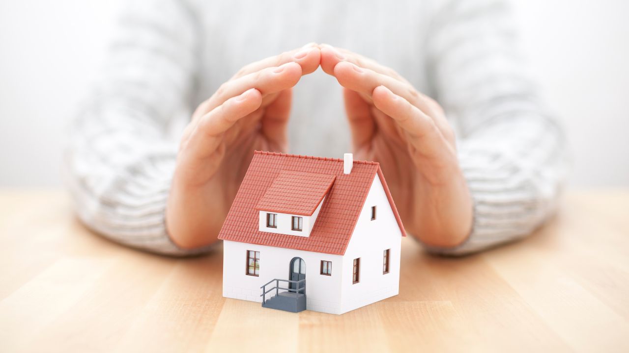 A hand protecting a house | Scott Legal, P.C. A hand protecting a house