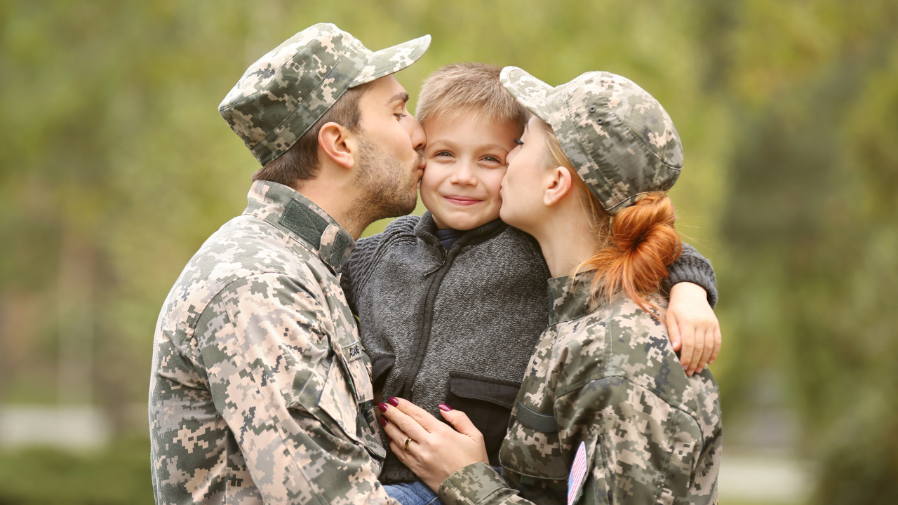 A military couple embracing their child | Scott Legal, P.C. A military couple embracing their child