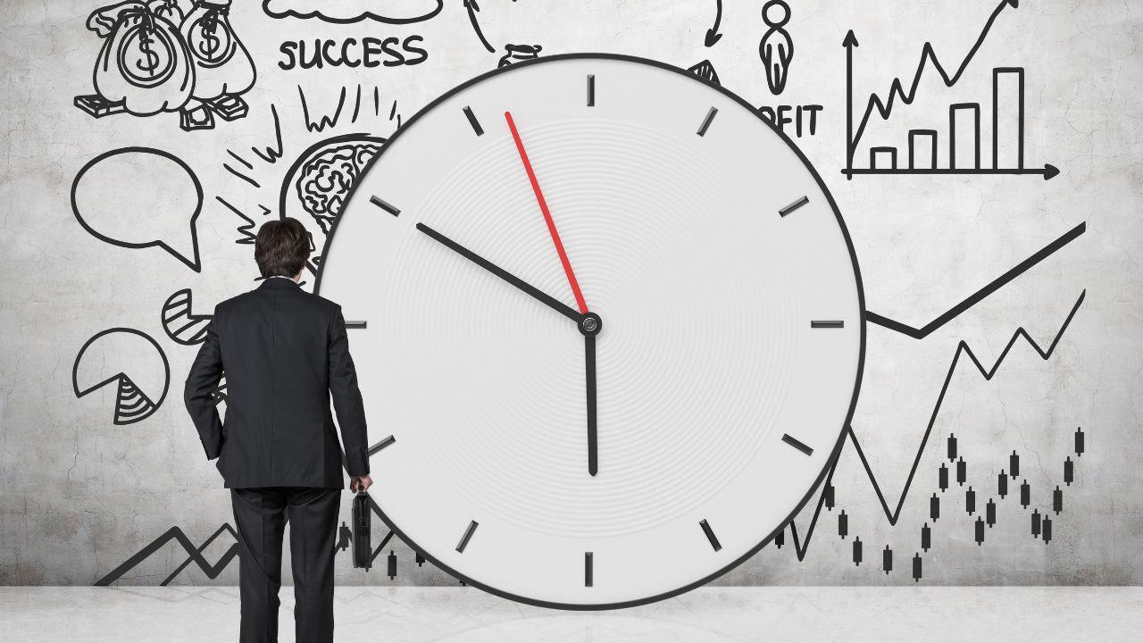 A man standing in front of a clock | Scott Legal, P.C. A man standing in front of a clock