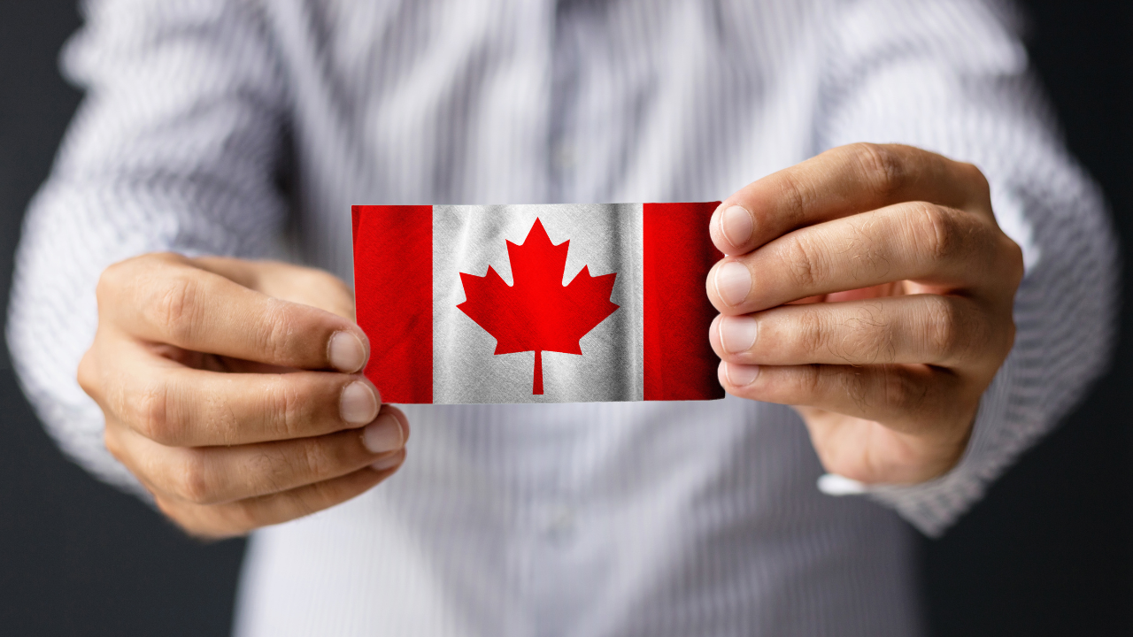 A business man holding a Canadian flag | Scott Legal, P.C. A business man holding a Canadian flag
