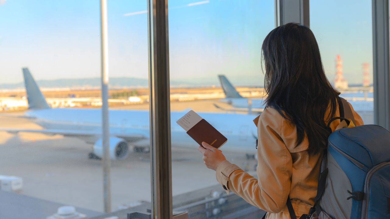 A woman at the airport waiting for her flight to board | Scott Legal, P.C. A woman at the airport waiting for her flight to board