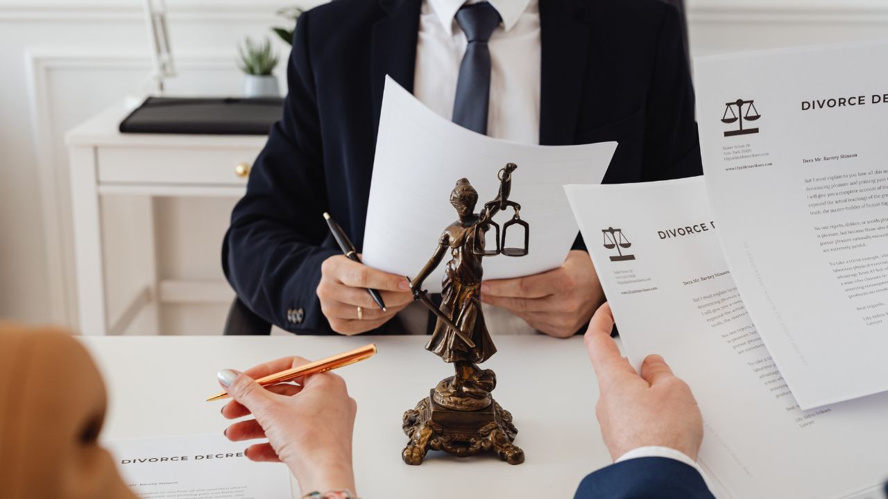 A lawyer and his clients going over divorce papers | Scott Legal, P.C. A lawyer and his clients going over divorce papers