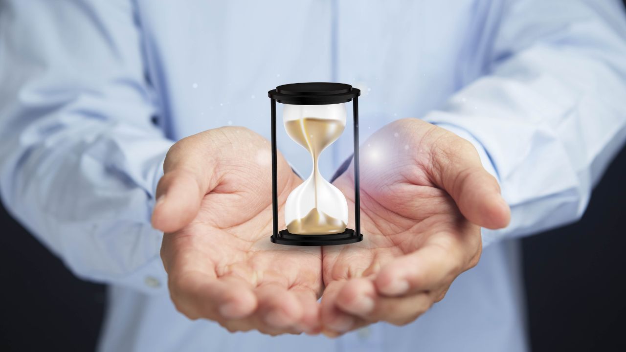 A man holding an hour glass | Scott Legal, P.C. A man holding an hour glass