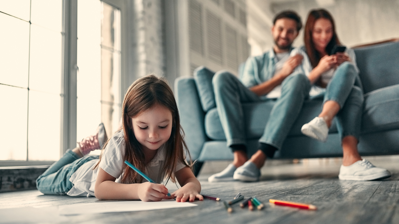 A happy family watching their daughter color | Scott Legal, P.C. A happy family watching their daughter color