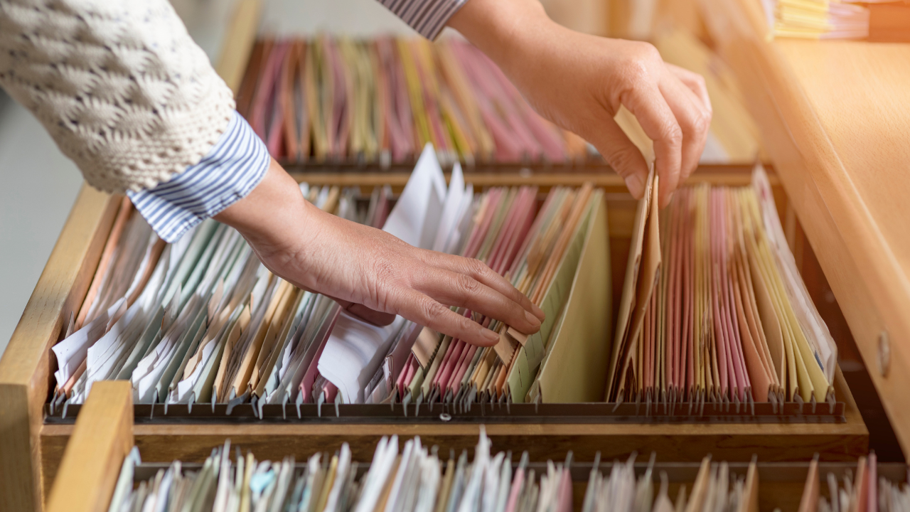 A woman going through a bunch of files in a filing cabinet | Scott Legal, P.C. A woman going through a bunch of files in a filing cabinet