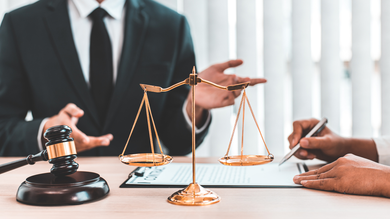 a lawyer in their office with the scales of justice and a gavel on their desk | Scott Legal, P.C. a lawyer in their office with the scales of justice and a gavel on their desk