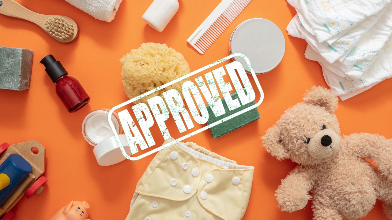 A bunch of baby products laid out on a table with an approved stamp over them | Scott Legal, P.C. A bunch of baby products laid out on a table with an approved stamp over them