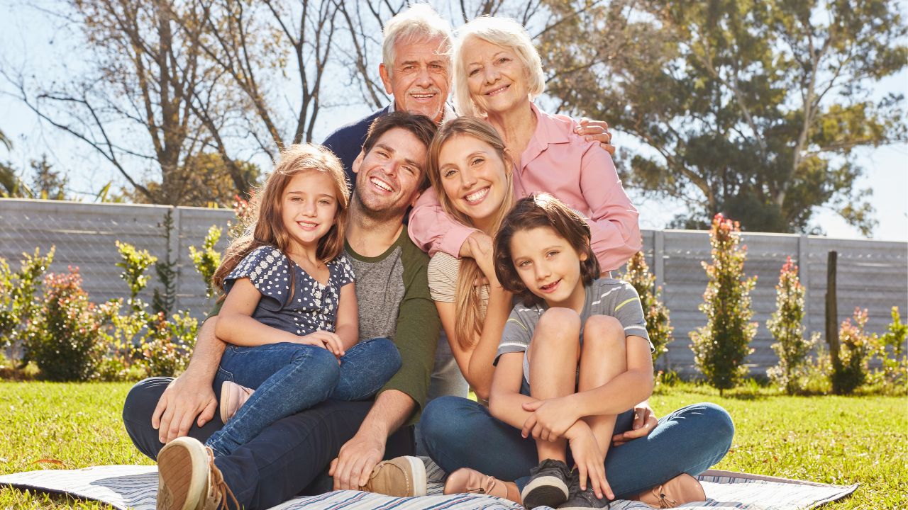 An extended family | Scott Legal, P.C. An extended family sitting on the grass at a park