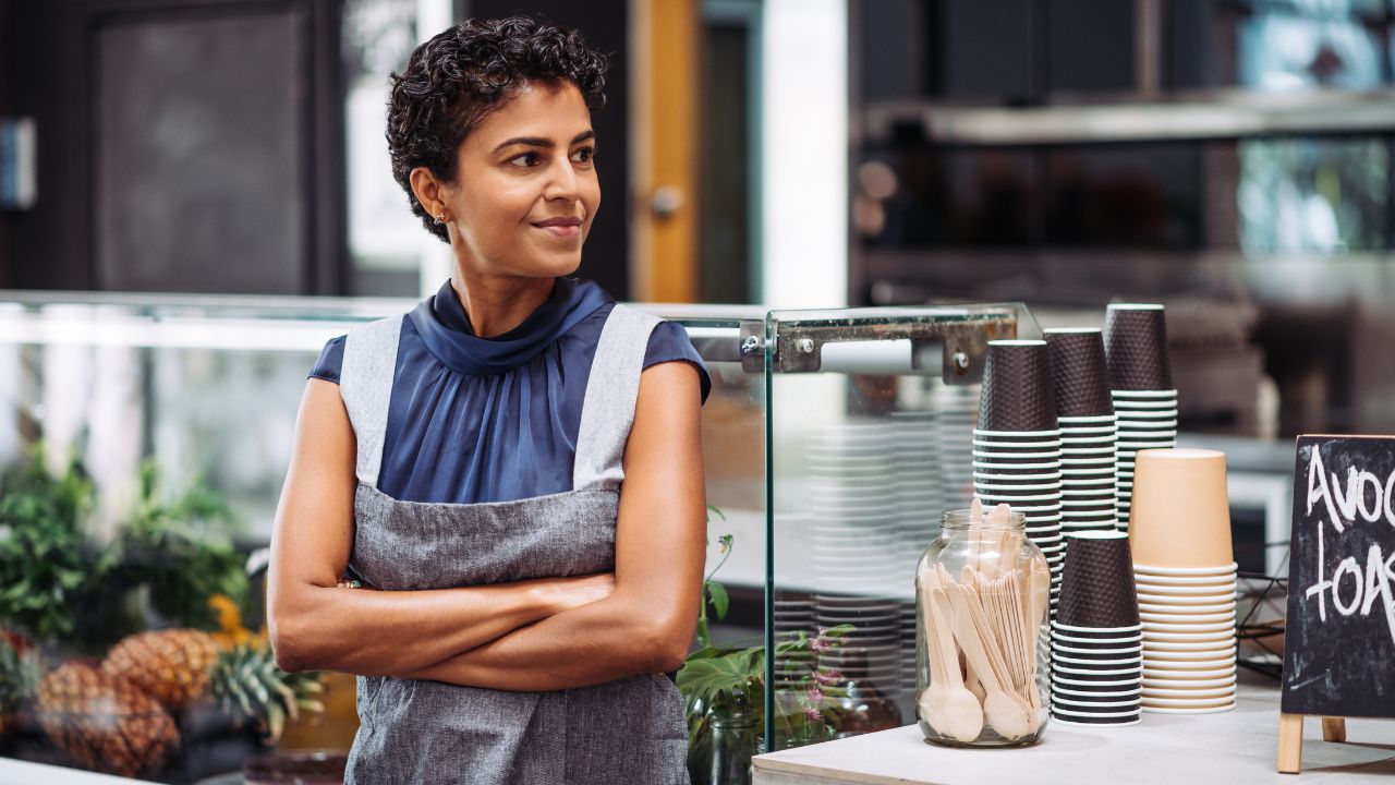 A self employed woman standing outside of her business | Scott Legal, P.C. A self employed woman standing outside of her business