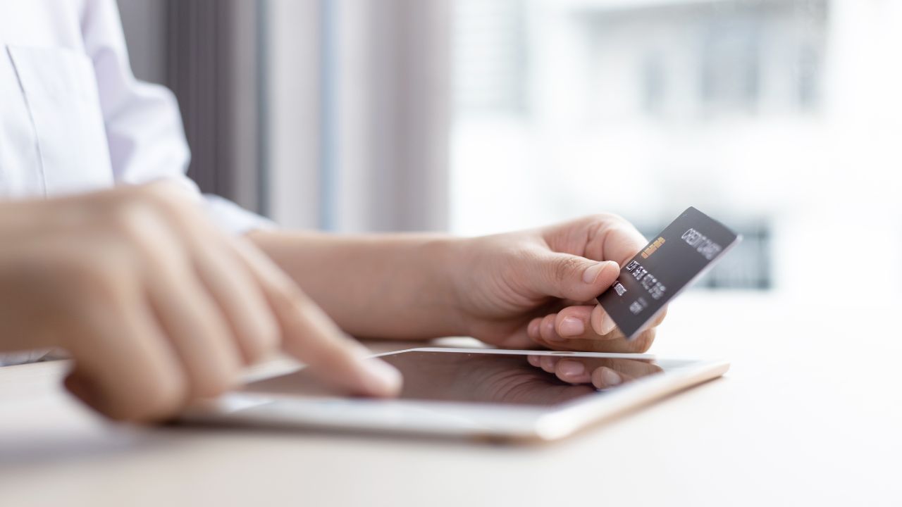 A person processing a credit card payment | Scott Legal, P.C. A person processing a credit card payment