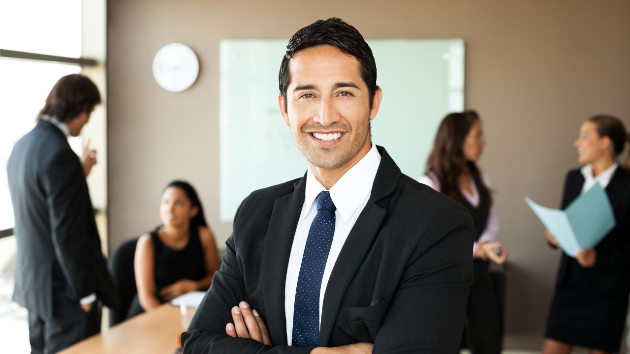 A manager standing in a board room with his team | Scott Legal, P.C. A manager standing in a board room with his team