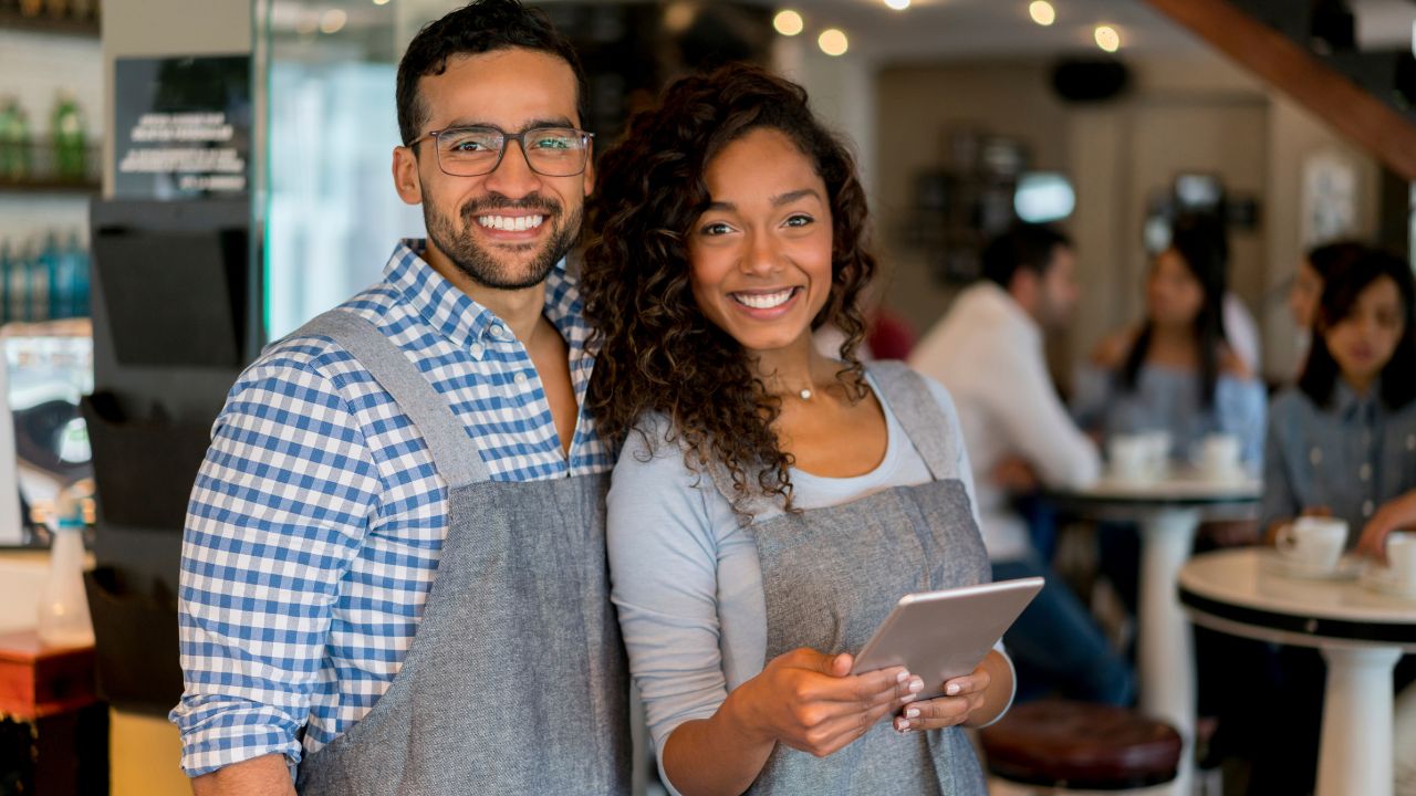Two smiling business owners working at their business | Scott Legal, P.C. Two smiling business owners working at their business