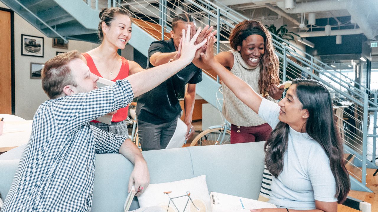 A group of people high fiving each other in celebration for good news | Scott Legal, P.C. A group of people high fiving each other in celebration for good news