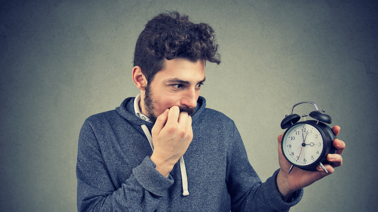 A man anxiously holding an alarm clock | Scott Legal, P.C. A man anxiously holding an alarm clock