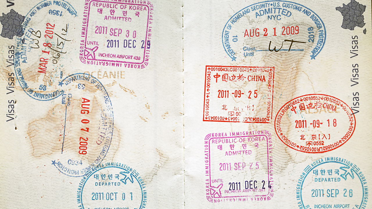 A passport full of travel visas and stamps | Scott Legal, P.C. A passport full of travel visas and stamps