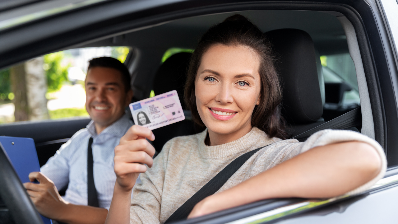 A woman in a car showing her driver's license | Scott Legal, P.C. A woman in a car showing her driver's license