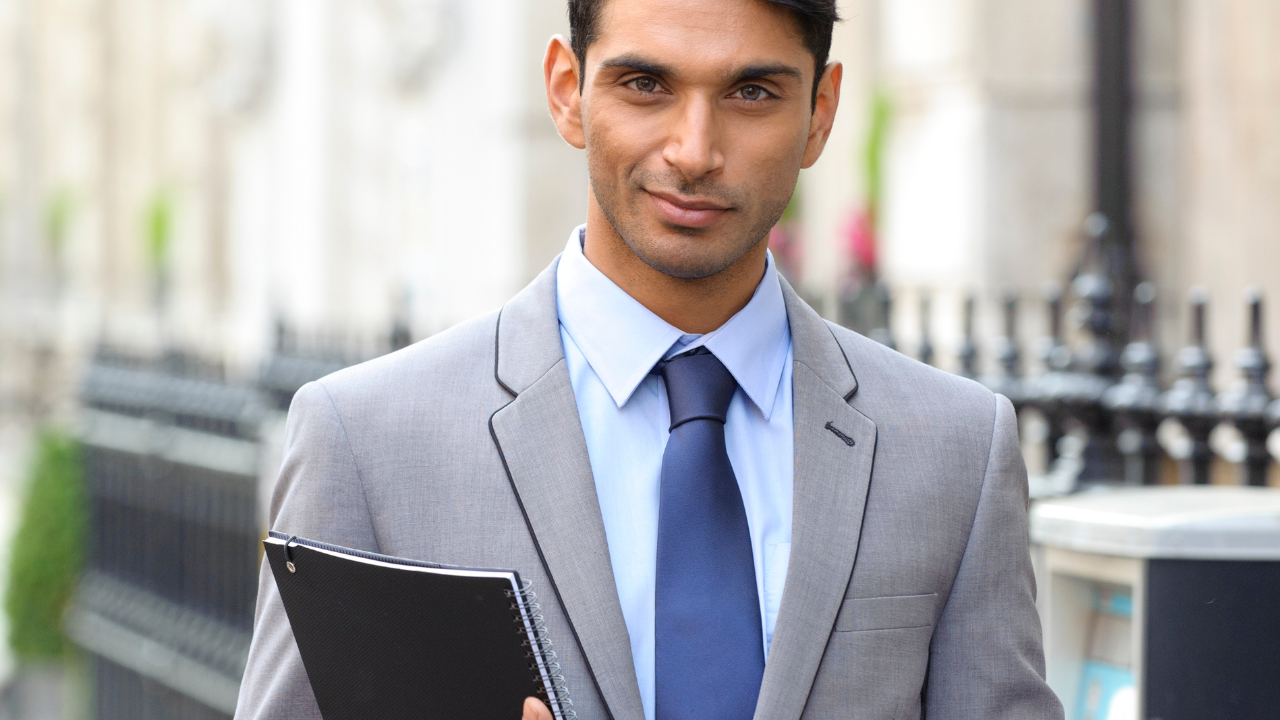 A business man holding a clipboard | Scott Legal, P.C. A business man holding a clipboard