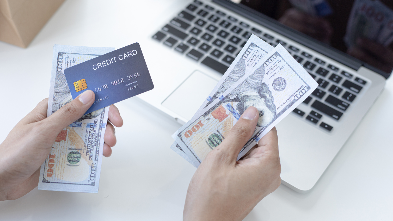 A man holding a credit card and money to pay his filing fees with | Scott Legal, P.C. A man holding a credit card and money to pay his filing fees with