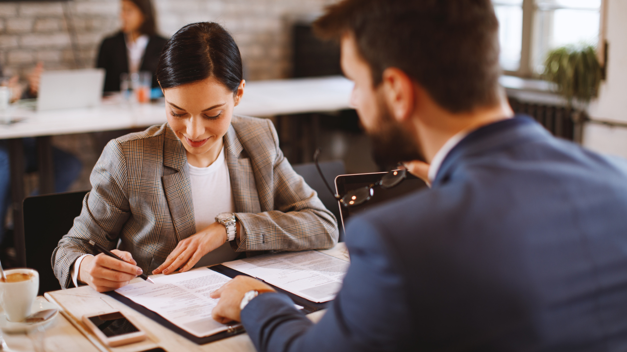 An employer and employee signing a contract | Scott Legal, P.C. An employer and employee signing a contract